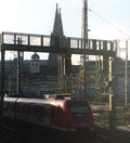 Train passing with the Cologne cathedral spire in the background. 